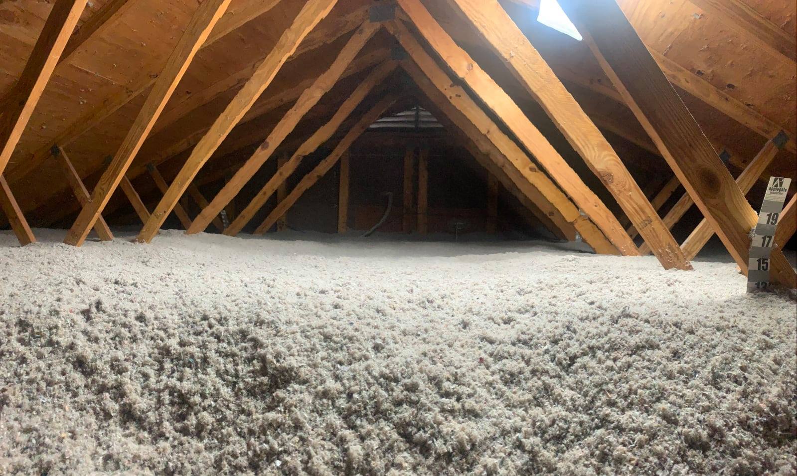 Blown-in fiberglass insulation being professionally installed in a Los Angeles attic